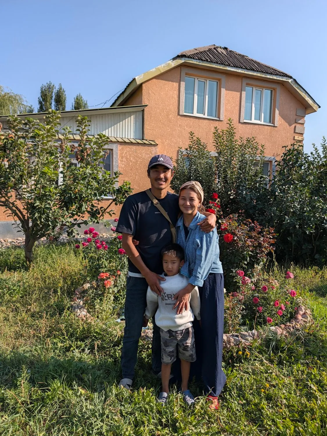 Our family standing among the roses in the garden in front of our house
